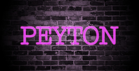 first name Peyton in pink neon on brick wall