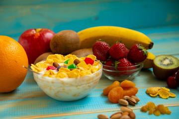 Tasty cornflakes with milk and fruits  in glass bowl 