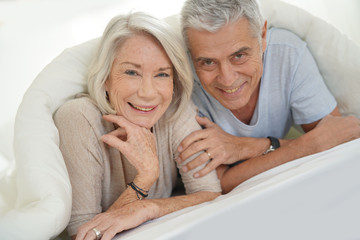  Portait of happy attractive senior couple in bed