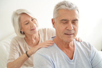  Senior woman rubbing husband's shoulders