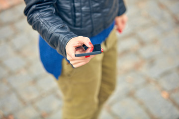 Woman using modern smartphone on the street.