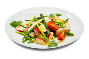 Vegetable salad with green onion radish and tomatoes. On a white plate and a white background