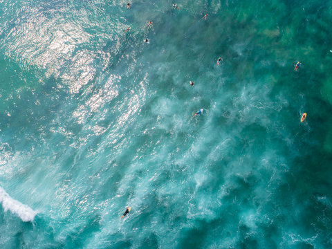 Aerial view from drone of surfers paddling for catching waves during surfing in the indian ocean