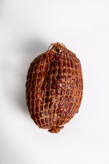 Szynka wieprzowa wędzona w siatce na białym tle © JacZia