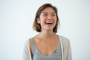 Portrait of laughing young Asian woman. Ecstatic girl standing with positive expression. Joy and positivity concept