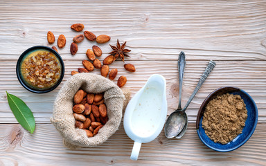 Cocoa powder and cacao beans on wooden background.