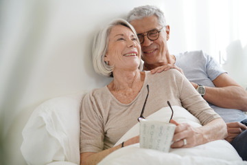 Portrait of senior couple relaxing in bed