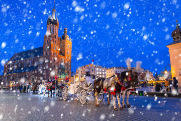 Fototapeta premium Old town of Krakow on a cold winter night with falling snow, Poland