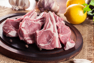 Raw fresh lamb chops on wooden cutting board