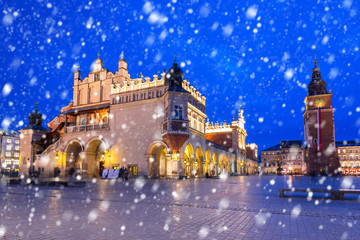 Obraz premium Old town of Krakow on a cold winter night with falling snow, Poland