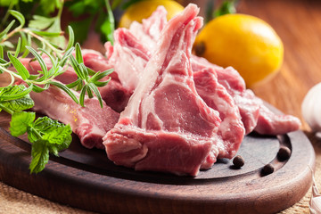 Raw fresh lamb chops on wooden cutting board