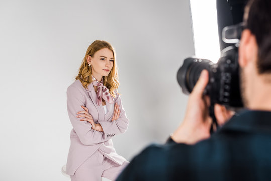 cropped shot of photographer shooting attractive young woman in photo studio