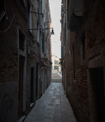 Narrow dark streets of Venice. Brick walls