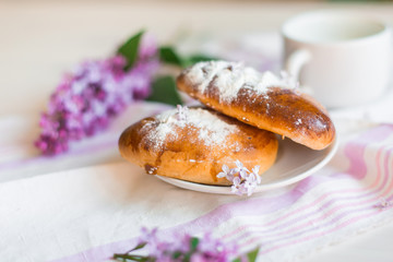 Delicious bakery cakes, buns with jam and violet flowers. Food and spring concept