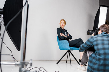 photographer shooting beautiful young woman in photo studio
