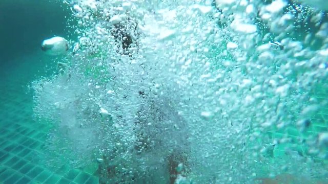 Pretty young woman jumps with Go-pro camera in swimming pool. Slow motion. 1920x1080