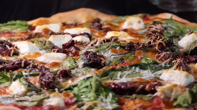 Pizza with spinache dried tomatoes and feta cheese. Spin shot.