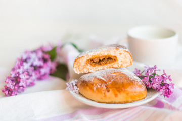 Fototapeta na wymiar Delicious bakery cakes, buns with jam and violet flowers. Food and spring concept