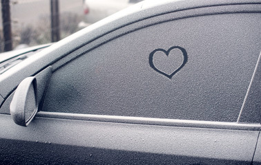 heart symbol on frozen car window in winter