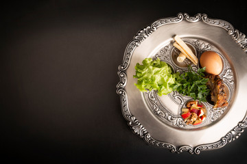 Seder, kolacja z okazji Paschy.  Sederowy talerz na ciemnym tle © JacZia