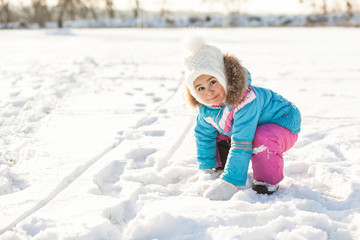 Fototapeta na wymiar Happy little girl having fun in the snow