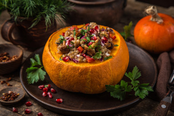 whole pumpkin stuffed with barley and vegetables, served with pomegranate and parsley