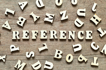 Letter block in word reference with another letter on wood background
