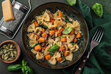 pumpkin farfalle pasta with pumpkin seeds and cheese in bowl