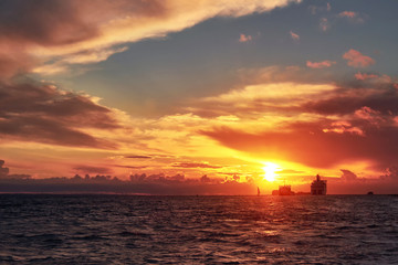 Sea sunset with ship ferry and boat on horizon