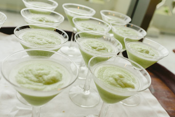 Many ice cream glasses ready to be served by a waiter during a wedding.