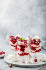 Eton mess, traditional english dessert, meringues, whipped cream, berry sauce and fresh raspberry in  glass
