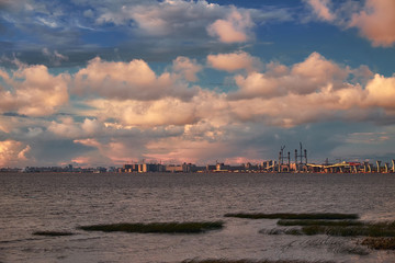 Fototapeta premium Sea landscape with bridge road construction and cranes on horizon in sunset light