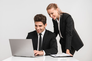 Smiling business couple wearing suits isolated