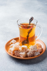 Turkish delight with hazelnut in carved metal bowl and tea in glass Cup, selective focus