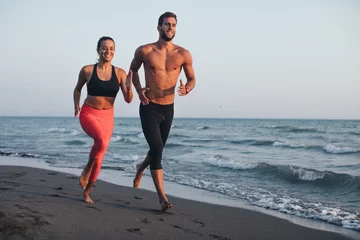 Papier Peint photo Lavable Jogging Man and Woman Running on Sandy beach