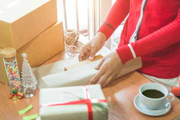 Woman holding Christmas presents laid on a wooden table background