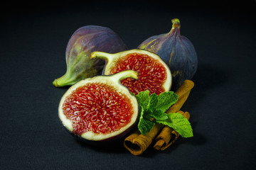 figs, whole and half on green wooden background