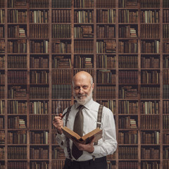 Academic professor in the library holding a book