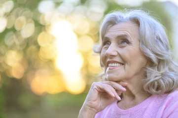 Close up portrait of senior woman praying outdoors