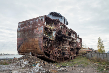 Huge rusty pieces of decommissioned marine ship that was cut and left on the shore.