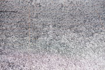 The windshield of car standing on the street is covered with snow. Winter background.