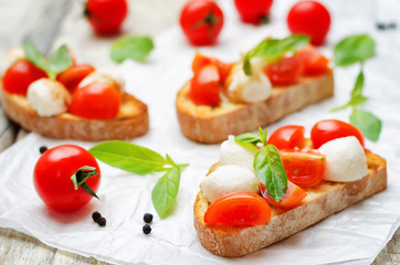 Caprese bruschetta with fresh tomatoes and Basil leaves