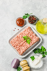 Minced meat, herbs, oil salt and pepper. Top view, space for text.