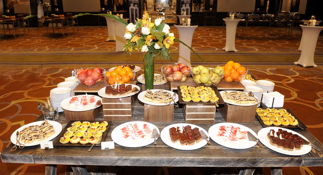 Catering food buffet table with cold snacks, mini sandwiches, pastry, meat and salads. Delicious appetizers on the table, self service