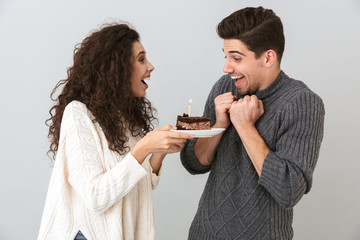 Cheerful couple wearing sweaters standing isolated