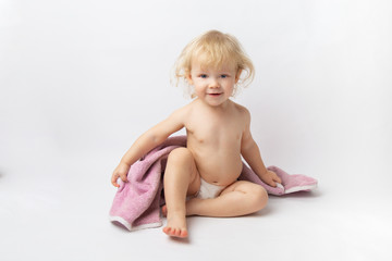 portrait of a little Caucasian baby girl in towel after a shower on a white background
