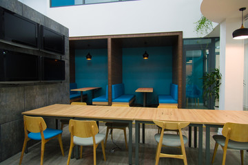 Long table with chairs around placed in modern business hall. Creative coworking space for meeting. Interior concept 