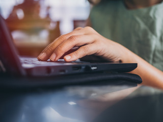 Hands working with keyboard on black laptop computer