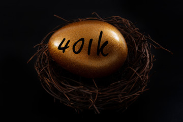 Financial planning, pension fund and retirement plan concept with a golden egg in a nest isolated on black with dark moody high contrast lighting with the text 401k
