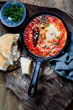Eggs in Purgatory, eggs, baked in very spicy tomato sauce, sprinkled with parsley and parmigiana
